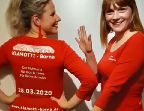 Anne und Kathleen 2020 in roten KLAMOTTI-Shirts, auf dem Rücken der Aufdruck mit Flohmarkt-Termin und Website