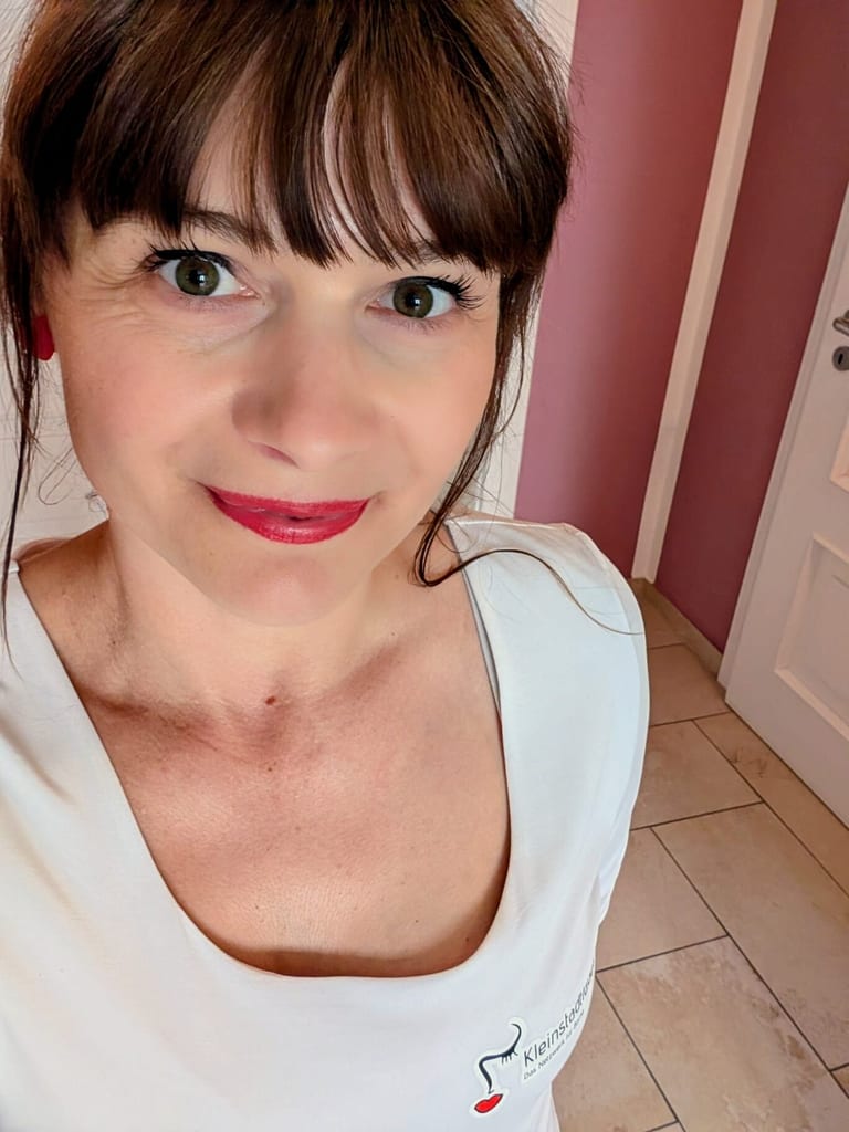 Anne mit dunklem Pony und rotem Lippenstift, Selfie im Kleinstadtladys-Shirt